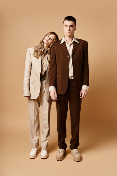 sophisticated man in debonair suit posing next to his beautiful girlfriend who looking at camera - Fotó, kép