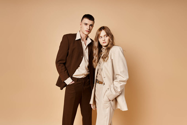elegant young woman in stylish suit posing with her handsome boyfriend and looking at camera - Foto, Imagem