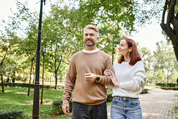 Adulti coppia amorevole in abiti casual camminare insieme in un ambiente tranquillo parco. - Foto, immagini