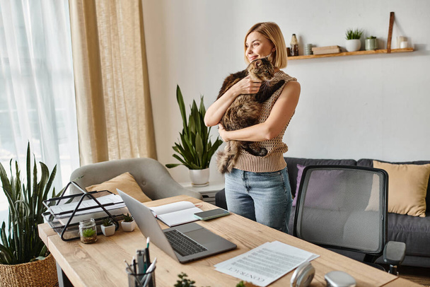 Kısa saçlı bir kadın kedisini göğsüne yakın tutuyor, evde sevgisini ve dostluğunu ifade ediyor.. - Fotoğraf, Görsel