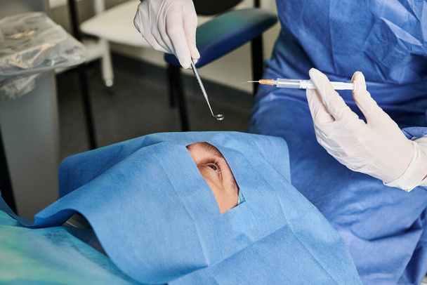 Un chirurgien en blouse chirurgicale opère un patient dans un cadre médical. - Photo, image