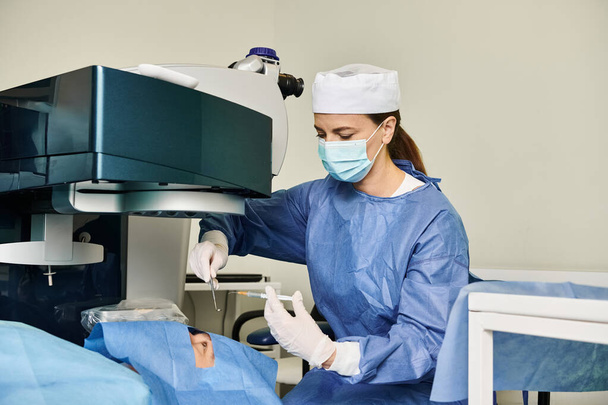 Egy nő sebészeti köpenyben lézeres látásjavító gépet működtet.. - Fotó, kép