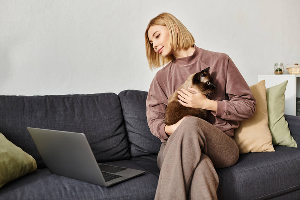 A woman in a cozy setting on a couch, holding her cat close, embodying a serene moment of companionship and relaxation. - Photo, Image
