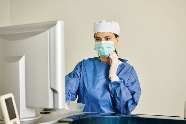Žena v ordinaci, oblečená v chirurgické masce a rukavicích, připravená na korekci laserového vidění. - Fotografie, Obrázek