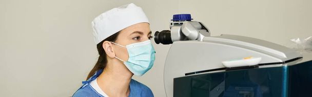 Frau mit chirurgischer Maske hält Laser-Sehkorrekturgerät. - Foto, Bild