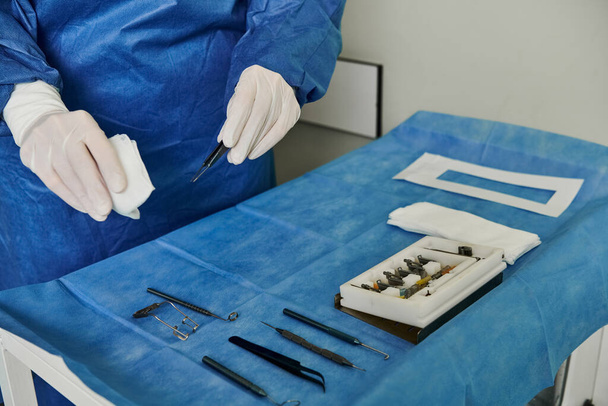 Una persona con un traje azul y guantes blancos en un consultorio médico para la corrección de la visión láser. - Foto, Imagen
