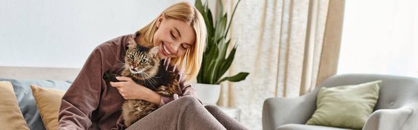 Een vrouw met kort haar houdt liefdevol haar kat in haar armen en toont genegenheid en verbondenheid tussen mens en huisdier. - Foto, afbeelding