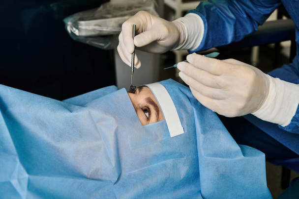 女性の顔にレーザービジョン補正を行うマスクを着用した外科医. - 写真・画像