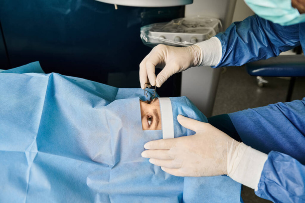 Una persona con una bata de hospital realiza una cirugía bajo una iluminación dramática. - Foto, imagen