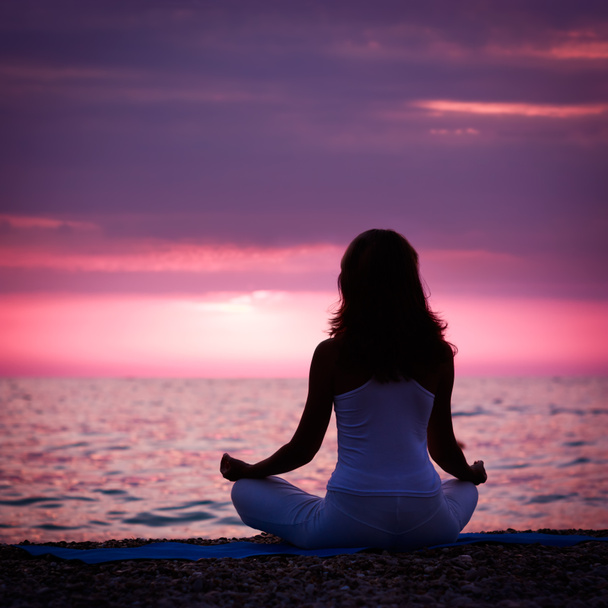 Nainen meditoi lootusasennossa meren rannalla
 - Valokuva, kuva