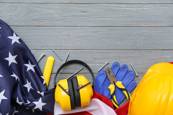 Pliers, protective gear and USA flag on grey wooden background. Labor Day celebration - Photo, Image