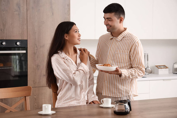 Счастливая молодая пара завтракает на кухне - Фото, изображение