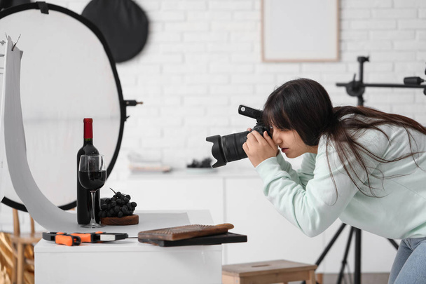 Fotografo di cibo femminile che fotografa il vino con l'uva in studio - Foto, immagini