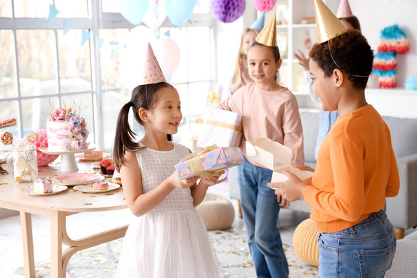 Cute little Asian girl giving gift to her friend at Birthday party - Photo, Image