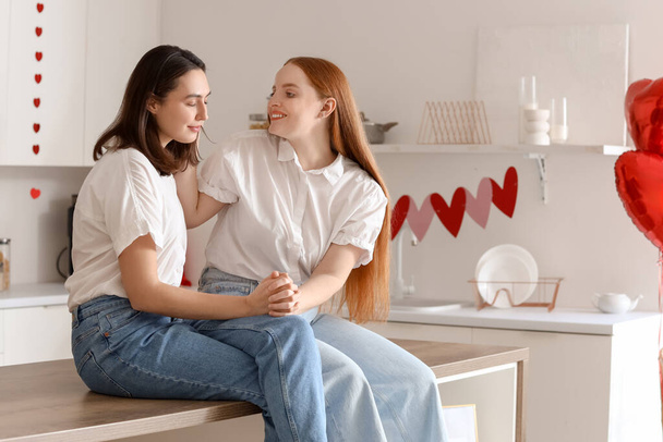 Jeune couple lesbien assis dans la cuisine le jour de la Saint-Valentin - Photo, image