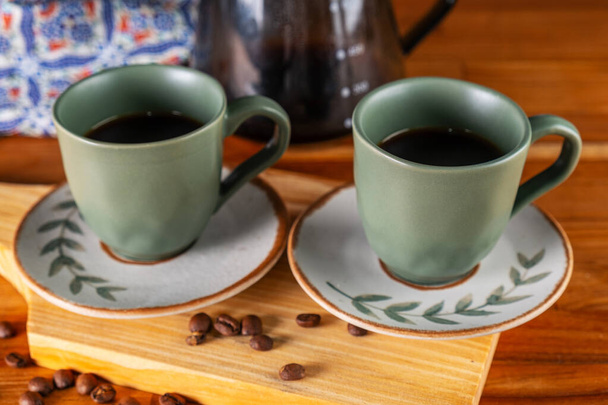 две чашки кофе и фильтр, используемый в фоновом режиме. - Фото, изображение