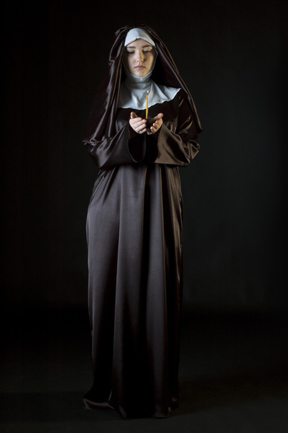 Nun holding candle - Foto, afbeelding