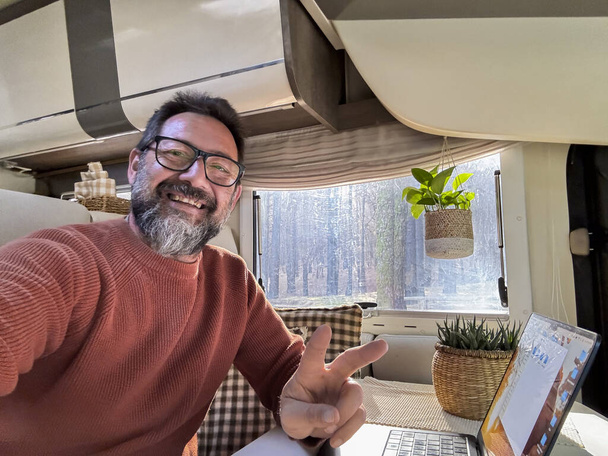 digital nomad working inside a camper van travel lifestyle vehicle vanlife using laptop computer and roaming internet connection. People and telecommuting remote worker. Life in motorhome. Modern - Photo, Image