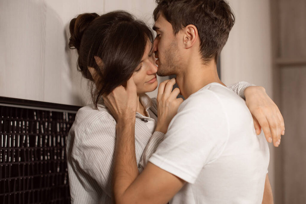 happy young couple at home. family indoors. love kiss in evening - Photo, Image