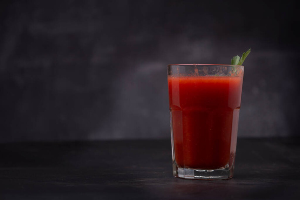 Čerstvý rajčatový džus ve sklenici s rajčaty, s petrželkou na tmavém pozadí - Fotografie, Obrázek