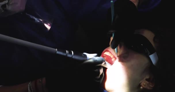 dentista utiliza una punta de turbina en una máquina de perforación para hacer un agujero en un diente enfermo con caries antes de llenarlo. Cuidado y salud de los dientes. - Imágenes, Vídeo
