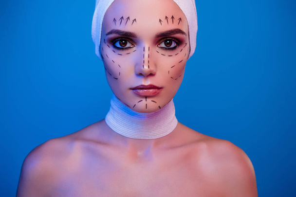 Photo of attractive girl plastic surgery patient having drawing correction marks on face look over neon background. - Photo, Image