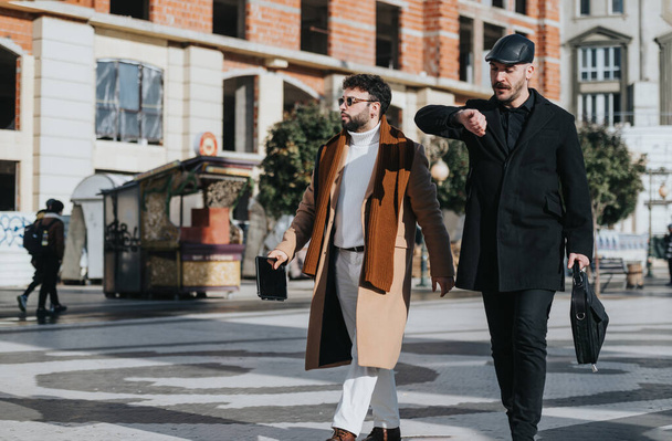 Dva stylové muži procházky a chatování na rušné městské ulici se sluncem. - Fotografie, Obrázek