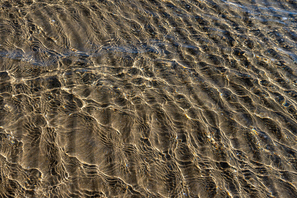Krystalicznie czysta woda morska tekstura z blaskiem słońca, tapety, tło natury - Zdjęcie, obraz