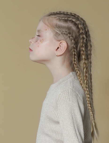 Portrait de mignonne petite fille blonde avec tresses boxer et paillettes om visage - Photo, image