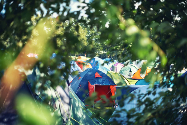 Nombreuses tentes, camping et plein air dans la nature pour un festival de musique. Rangée de chapiteaux arc-en-ciel posés sur le terrain lors de soirées musicales, animations et fêtes de carnaval, détente sur le camping de vacances. - Photo, image
