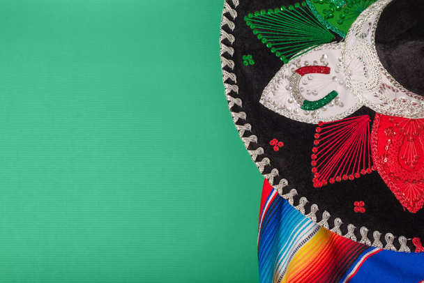 Mariachi hat and serape on green background. Mexican independence concept. Cinco de mayo background. - Photo, Image