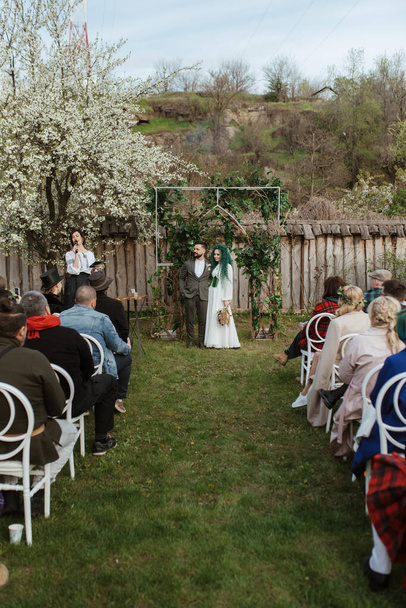 esküvői szertartás a friss házasok egy vidéki ház egy zöld dombon - Fotó, kép
