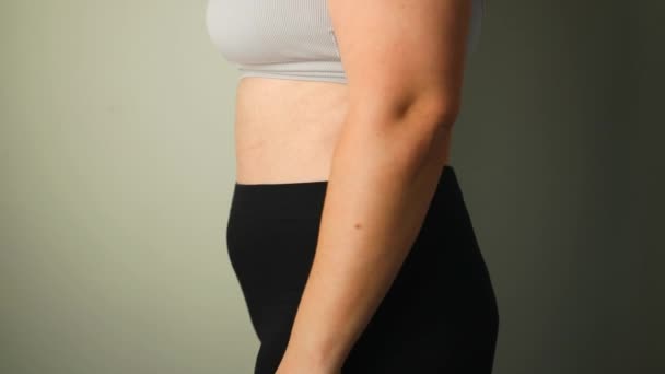 Primer plano de los pliegues de grasa en el vientre grande de la mujer con sobrepeso. Concepto de exceso de peso, obesidad femenina, dieta y problemas de sobrepeso. Imágenes FullHD de alta calidad - Imágenes, Vídeo