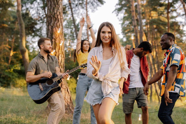 Monirotuinen ryhmä ihmisiä, kaunis hipster nainen tanssii taustalla ystäviä hauskaa - Valokuva, kuva