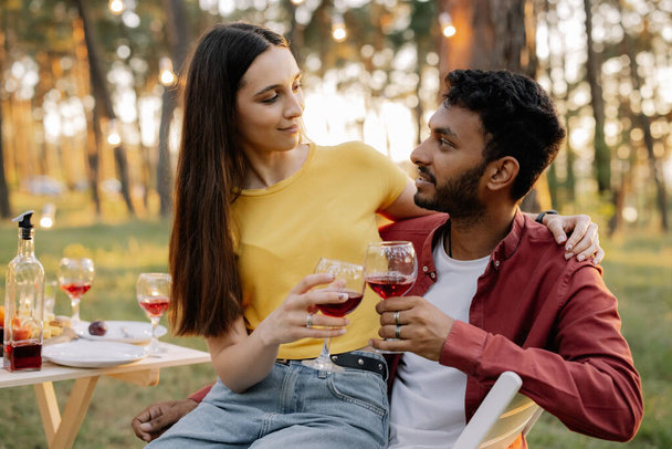 feliz casal multirracial beber vinho juntos em uma festa com amigos - Foto, Imagem