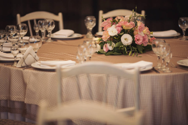 Schöne Blumen auf dem Tisch am Hochzeitstag. Tischdekoration mit Blumen Tischnummern und Kerzen. Blumenstrauß auf arrangiertem Tisch.  - Foto, Bild