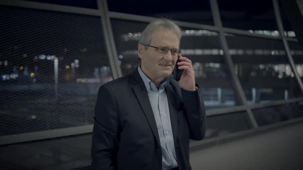 Ενθουσιασμένος ώριμος άνδρας που μιλάει χαρούμενα στο κινητό τηλέφωνο έξω - Πλάνα, βίντεο