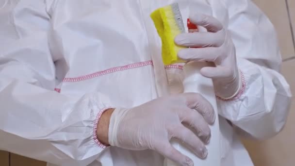 schimmelreiniging, beschimmelde badkamer en een man in een professioneel beschermend pak die chemicaliën spuit om schimmel en meeldauw te doden - Video