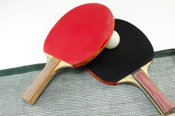 Dos raquetas de tenis de mesa y una red aislada
 - Foto, Imagen