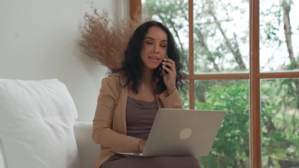 Mulher afro-americana falando ao telefone fazendo telesales ao usar o computador portátil para o trabalho crucial na internet. Escrita de conteúdo online ou secretário trabalhando em casa. - Filmagem, Vídeo
