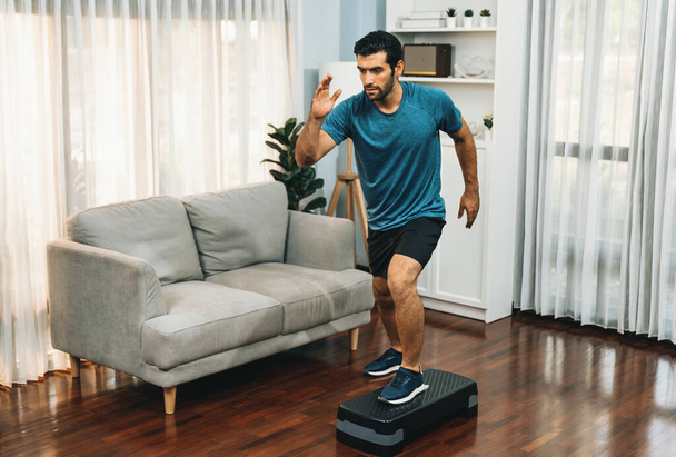 Athletic and sporty man running posture at home body workout exercise session for fit physique and healthy sport lifestyle at home. Gaiety home exercise workout training. - Photo, Image