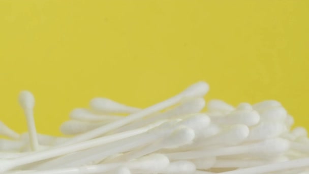 A pile of cotton swabs arranged on a vibrant yellow background, resembling petals of a flower in a macro photography art, creating a visually striking image. - Footage, Video