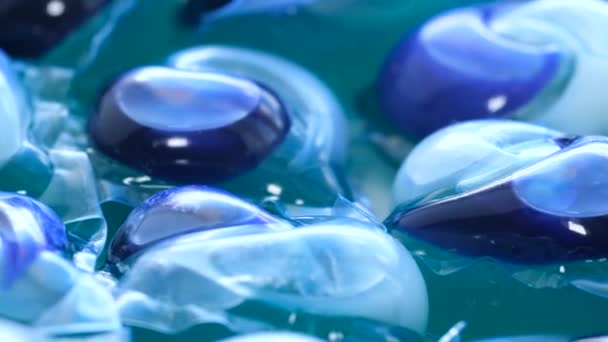 Ένα δοχείο με κοντινή θέα των θαλάμων απορρυπαντικού πλυντηρίου σε ηλεκτρικό μπλε υγρό, που μοιάζει με νερό. Το μοτίβο και το χρώμα μοιάζουν με τη θαλάσσια βιολογία, αλλά τονίζει τη χρήση του πλαστικού σε τέτοια προϊόντα. - Πλάνα, βίντεο