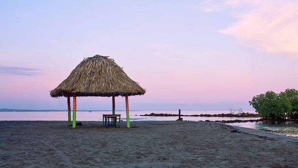 Palapas lub chaty zbudowane na plażach kolumbijskiego regionu Karaibów używane jako schronienie przed słońcem lub deszczem oraz do jedzenia i odpoczynku. - Zdjęcie, obraz