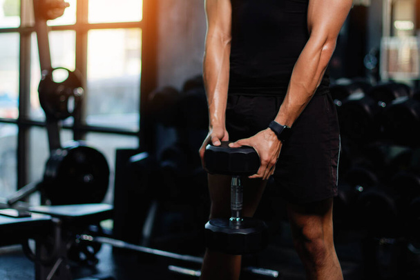 Übung mit Kurzhanteln Heben von Gewichten zum Aufbau starker Armmuskeln, eine Aktivität für eine gute körperliche Gesundheit. - Foto, Bild