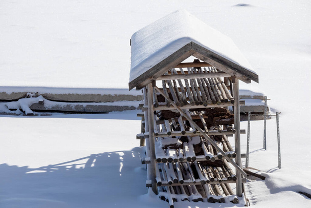 pieni puinen hirsivaja tavaroiden varastointiin on peitetty lumella - Valokuva, kuva