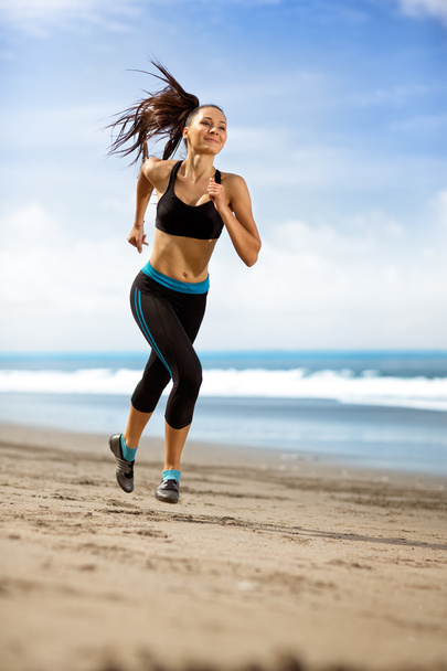 sport woman running in sea coast on sunny day - Foto, Bild