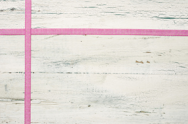 Vaaleanpunaiset nauhat valkoisella puupohjalla
 - Valokuva, kuva