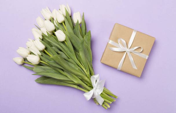 Bílá tulipán kytice s dárkem na barevném pozadí, horní pohled - Fotografie, Obrázek