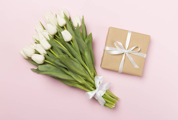 Weiße Tulpe Strauß und Geschenkbox auf farbigem Hintergrund, Ansicht von oben - Foto, Bild